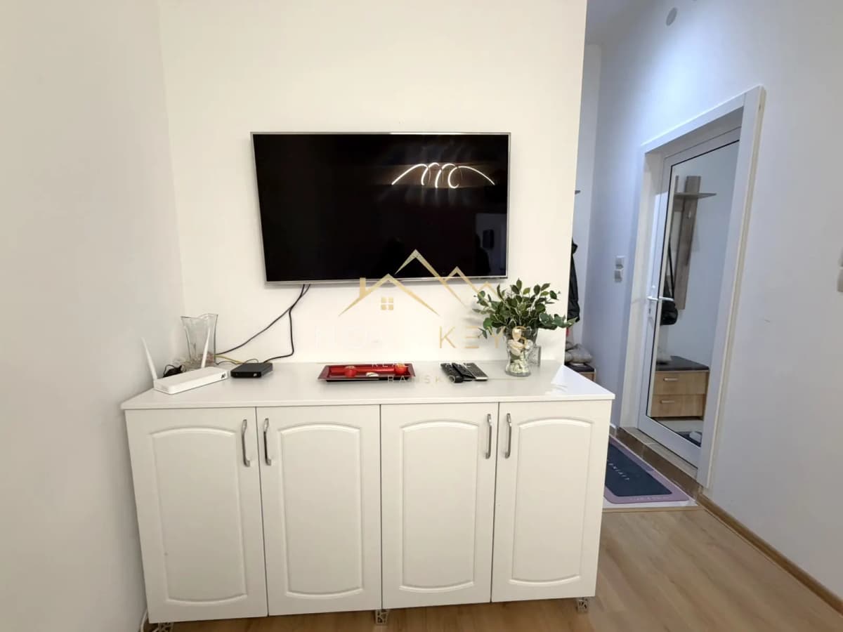 Wall-mounted TV above white cabinet, two-bedroom apartment for sale in Pirin Golf.