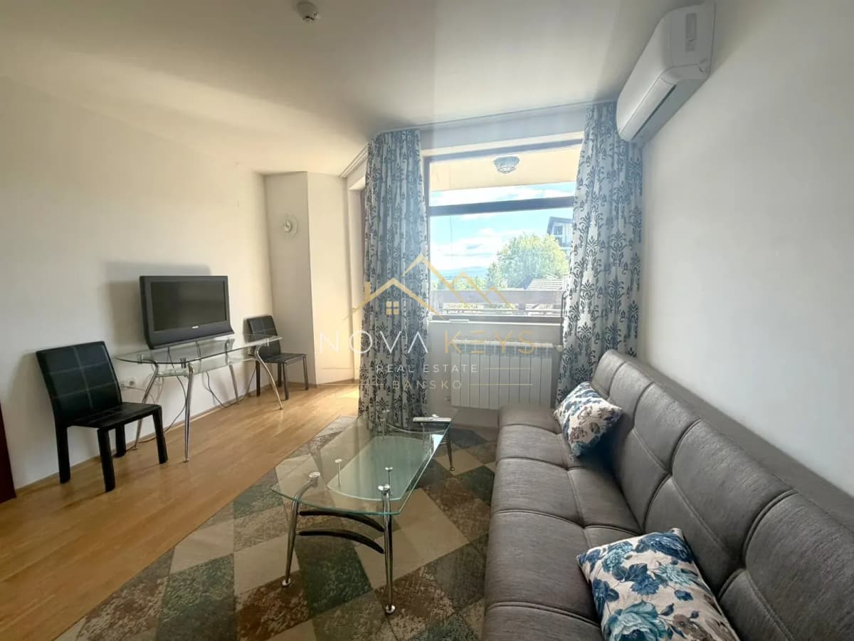 Living room with gray sofa and glass coffee table, two-bedroom apartment for sale in Razlog.