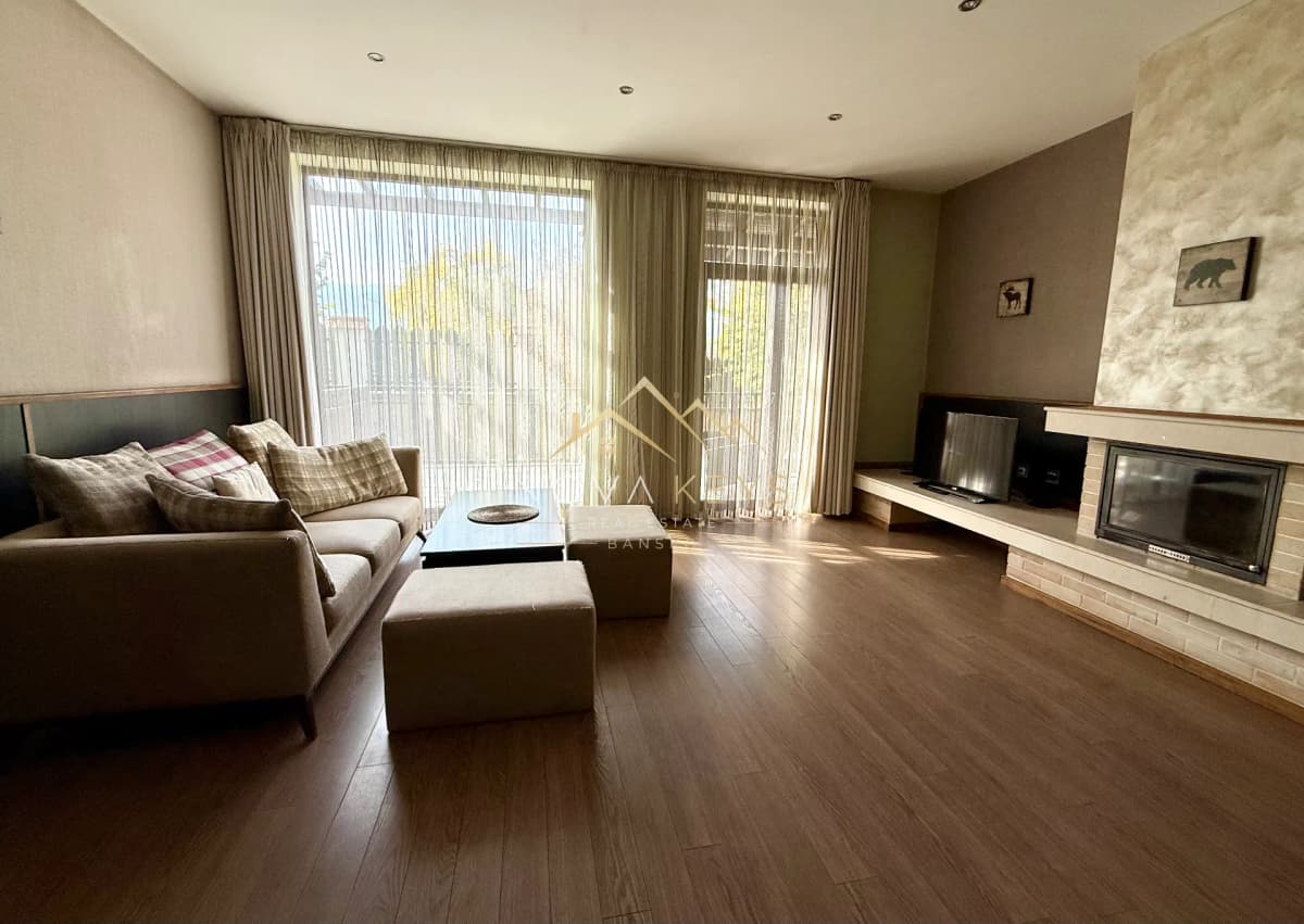 Living room with sectional sofa and fireplace, house for sale in Dobrinishte.