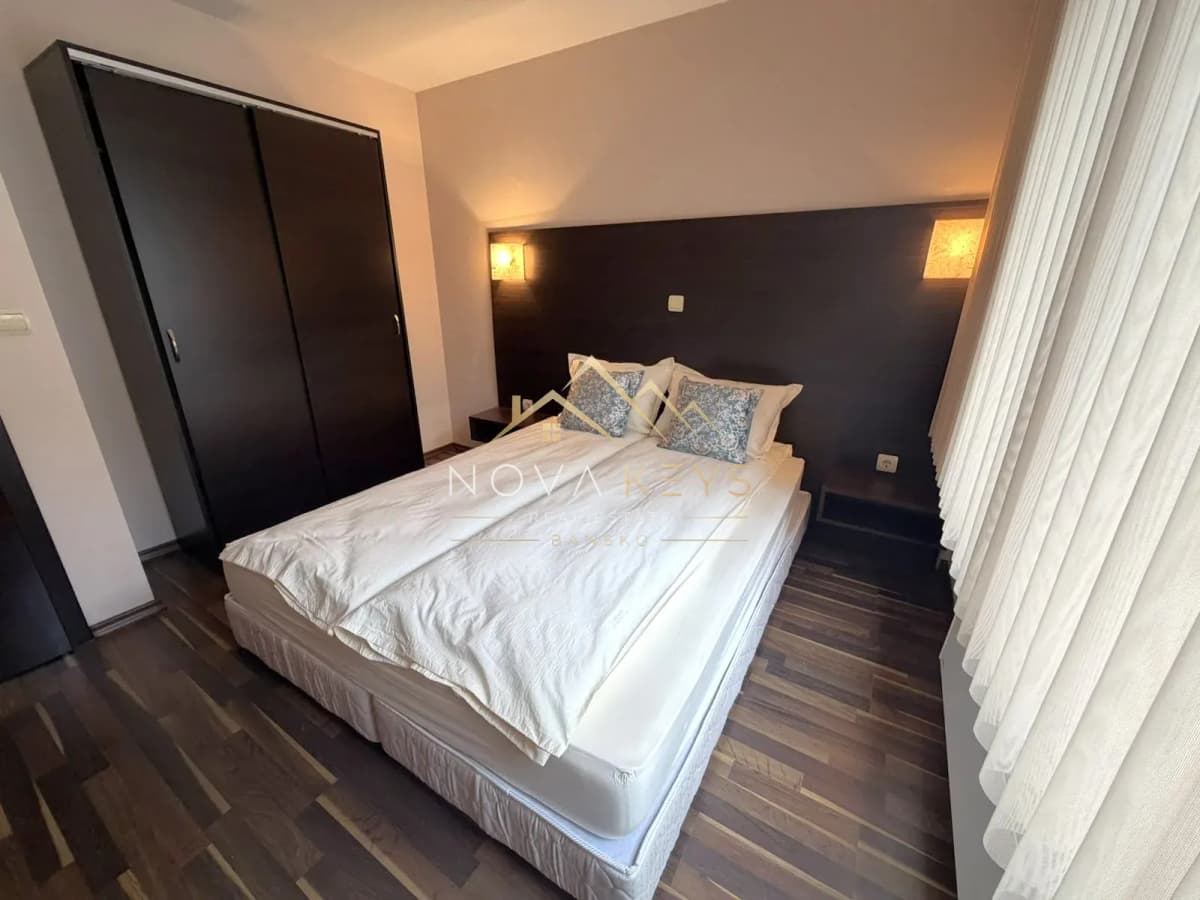 Bedroom with double bed, wardrobe, and wall lights, three-bedroom apartment for rent in the Bansko ski area.