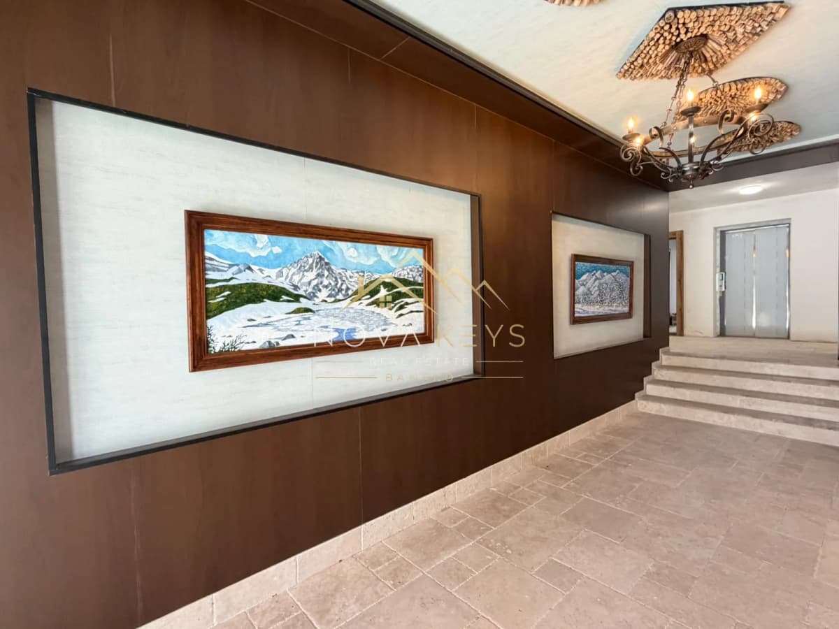 Lobby corridor with wall art and staircase, two-bedroom apartment for sale in the Bansko ski area.