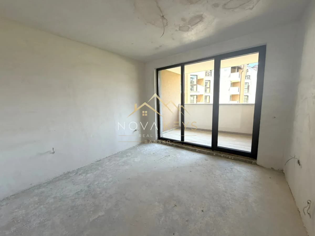 unfurnished room with sliding glass door and balcony, two-bedroom apartment for sale in the Bansko ski area.