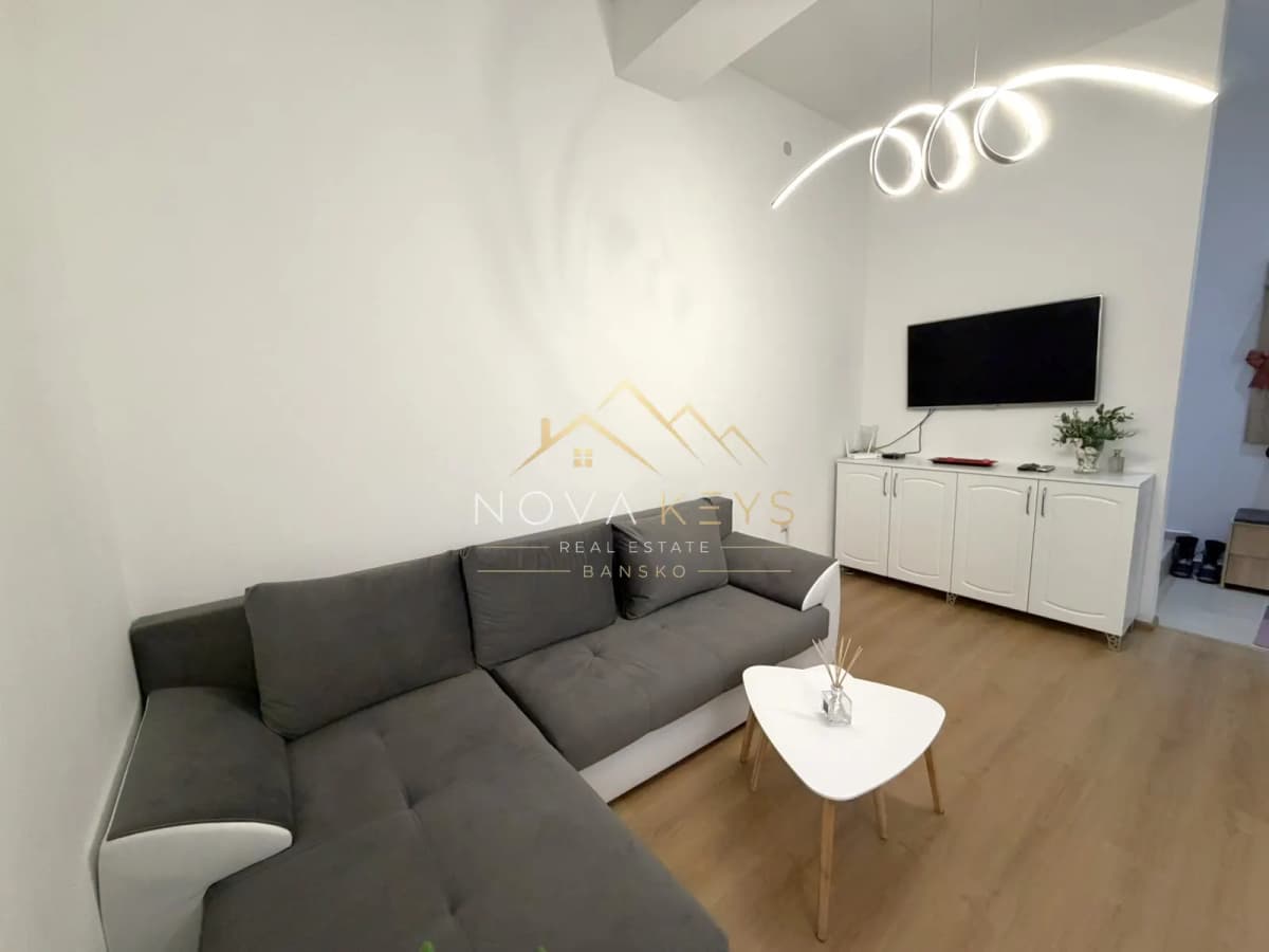 modern living room with sectional sofa and wall-mounted TV, two-bedroom apartment for sale in Pirin Golf.